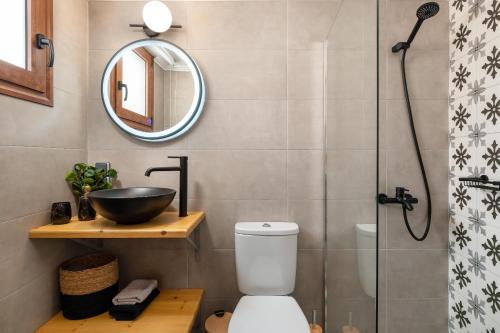 a bathroom with a toilet and a sink and a mirror at Antica Casa Dei Nonni in Archangelos
