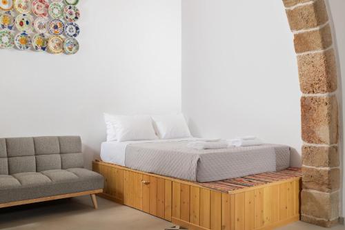 a bed and a couch in a room at Antica Casa Dei Nonni in Archangelos