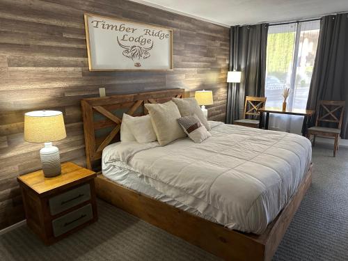 a bedroom with a bed and a wooden wall at Timber Ridge Lodge - Walking Distance from Downtown Gatlinburg in Gatlinburg
