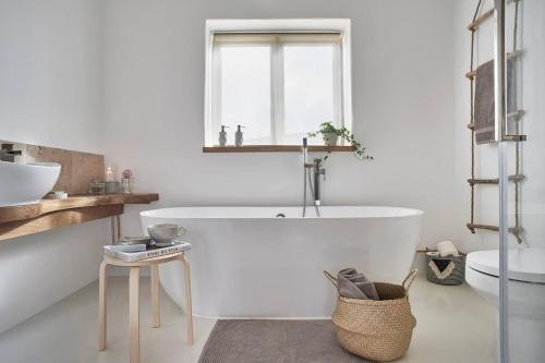a white bathroom with a tub and a sink at The Barn - Georgeham North Devon in Braunton