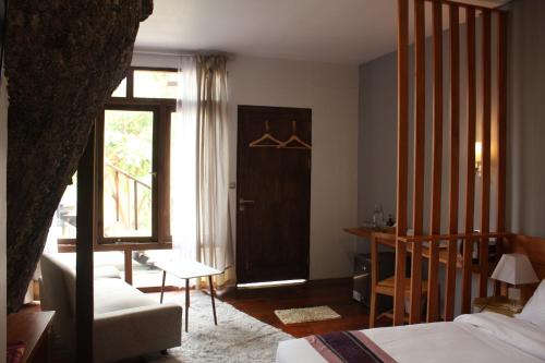 a room with a bed and a door with a window at Natuna Dive Resort in Ranai