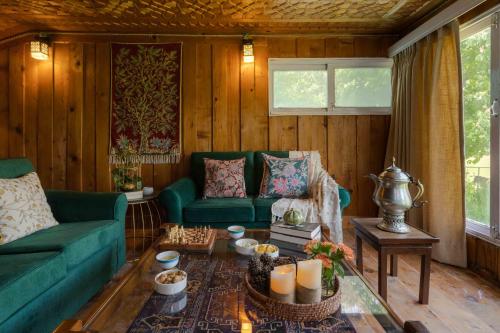 sala de estar con sofá verde y mesa en LohonoStays Villa Hill Retreat, en Pahalgām