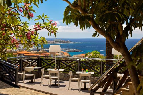a table and chairs on a balcony overlooking the ocean at Melia Jardines del Teide - Adults Only in Adeje