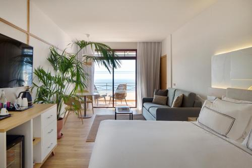 een woonkamer met een bed en een bank bij Melia Jardines del Teide - Adults Only in Adeje