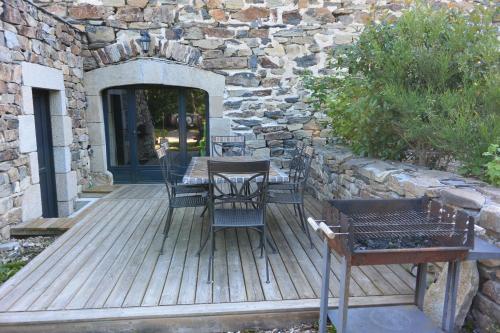a wooden deck with a table and chairs on it at Aux Pays Des Sucs in Saint-Hostien