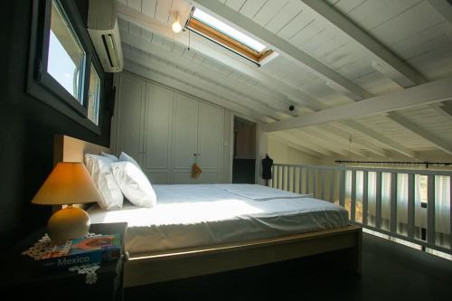 1 dormitorio con 1 cama con lámpara y balcón en Loft 35a, en Tesalónica