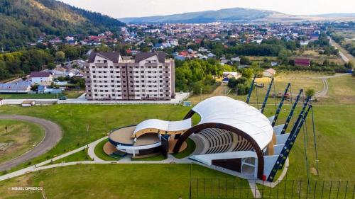 un banco en un campo con un edificio en el fondo en CITADEL VIEW en Tîrgu Neamţ