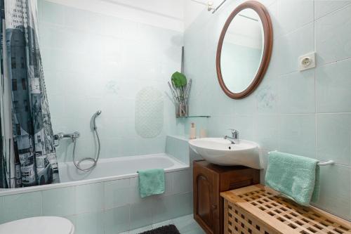 uma casa de banho com um lavatório, um espelho e uma banheira em Apartment Gracia with private parking and free internet em Porec