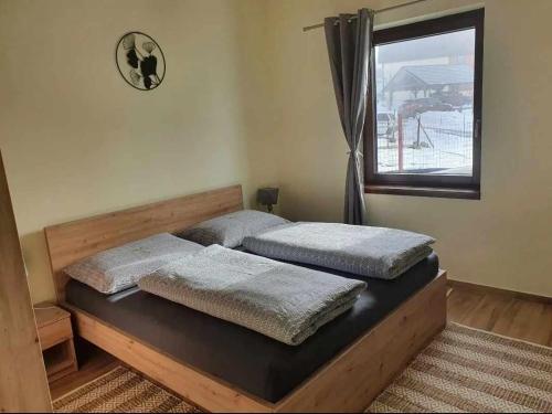 two beds in a bedroom with a window at Apartmány Zaky in Vrbov