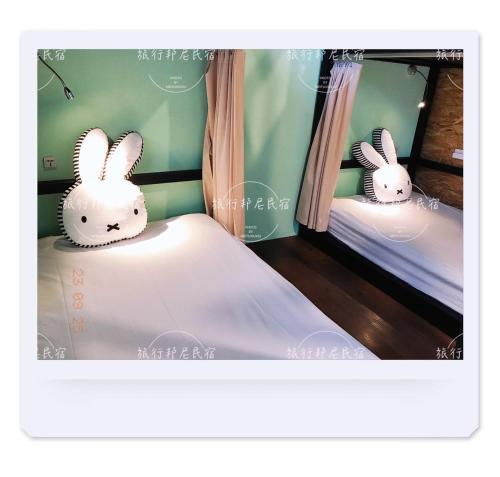 two bunnies sitting on two beds in a room at Tourist Bunny Hostel in Tamsui
