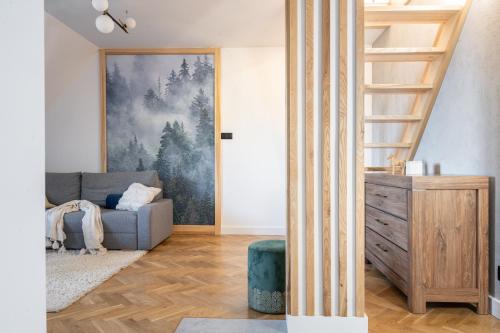 ein Wohnzimmer mit einer Treppe und einer Couch in der Unterkunft Studio Miła i Nido w Centrum APARTZAKOP in Zakopane