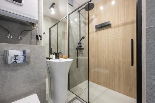 ein Bad mit einem Waschbecken und einer Dusche in der Unterkunft Studio Miła i Nido w Centrum APARTZAKOP in Zakopane