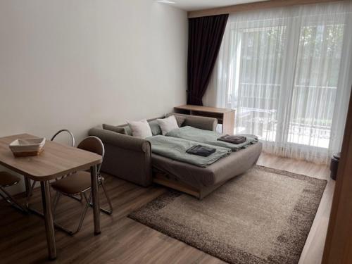 Sala de estar con cama, mesa y mesa en Inter Apartman, en Debrecen