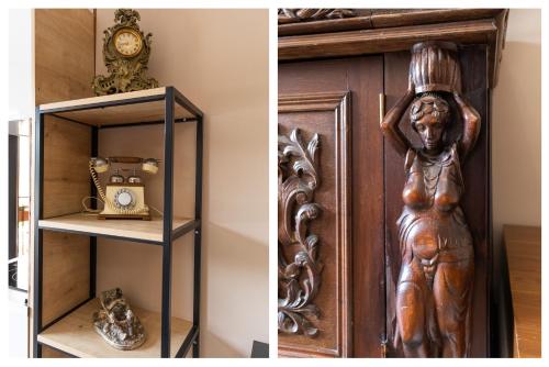 a wooden door with a statue next to a shelf with a clock at Honeymoon Apartments in Old Tbilisi in Tbilisi City