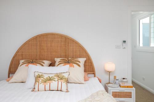 a bedroom with a bed with a wooden headboard at 32 Morrish Street in Port Macquarie
