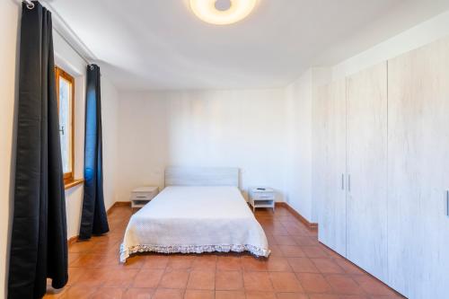 een slaapkamer met een bed in een witte kamer bij BORGO SMOL in Chianni