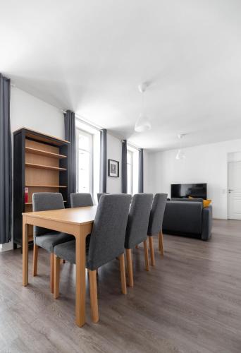 une salle à manger avec une table et des chaises en bois dans l'établissement Le Brit - Grand appartement design, 3 chambres, centre ville, à Vichy