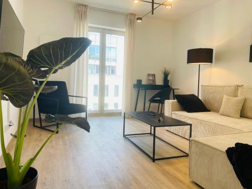 a living room with a couch and a table at LIGHTPLACE • Design • Boxspring • Balkon • 2 Smart TV •Innenstadt in Braunschweig