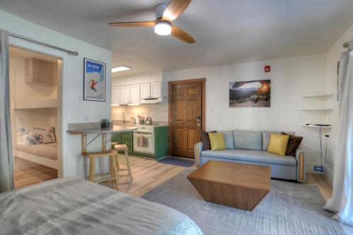 a living room with a blue couch and a kitchen at Studio Purgatory Townhome 111 in Durango Mountain Resort