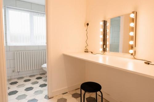 a bathroom with a counter with a mirror and a stool at Prenton House, 3BR Close to Liverpool in Birkenhead