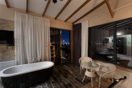 ein Bad mit einer Badewanne, einem Tisch und Stühlen in der Unterkunft Honeymoon Apartments in Old Tbilisi in Tbilisi City