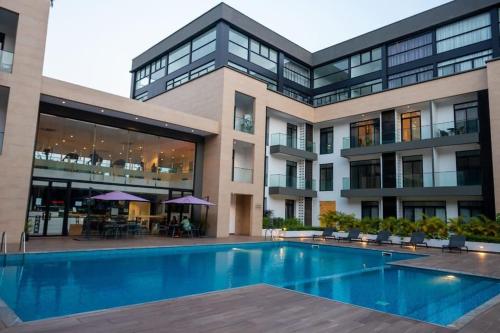 ein großes Gebäude mit einem Pool davor in der Unterkunft Paradise 1 bedroom Apartment @Embassy Gardens in Cantonments