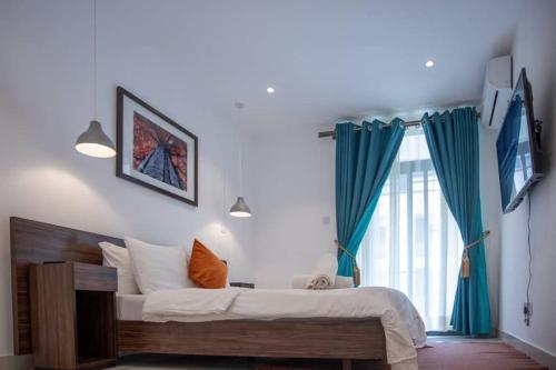 a bedroom with a large bed and a window at Paradise 1 bedroom Apartment @Embassy Gardens in Cantonments