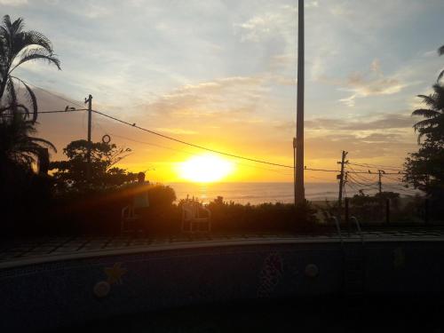 a sunset with the sun setting over the ocean at Padmatheertham Inn in Varkala