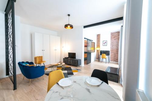 une salle à manger et un salon avec une table et des chaises dans l'établissement KASA ARTY - Tout équipé - Agréable et confortable, à Saint-Étienne