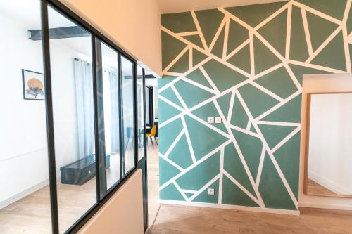 une fresque murale présentant un design géométrique dans un couloir dans l'établissement KASA ARTY - Tout équipé - Agréable et confortable, à Saint-Étienne