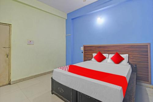 a bedroom with a large bed with red pillows at Hotel Satya Inn in Karīmnagar