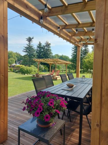 a wooden deck with a table and flowers on it at Apartamenti Dundaga XXL in Dundaga