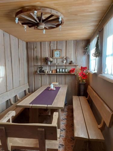 a dining room with a wooden table and benches at Apartamenti Dundaga XXL in Dundaga