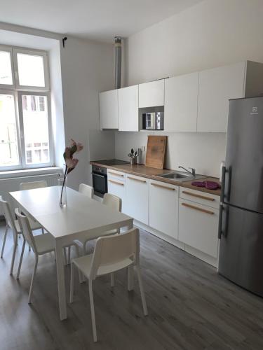 a kitchen with a table and chairs and a refrigerator at Only Ladies hostel - female only in Prague