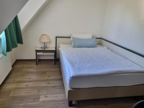 a bedroom with a bed and a side table at Sportpark Hotel Isernhagen in Isernhagen