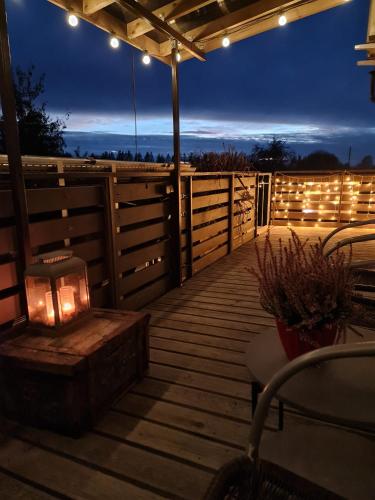 a wooden deck with a grill and lights on it at Apartamenti Dundaga XXL in Dundaga