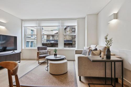 a living room with a couch and a tv at Bow Lane by Aeria Apartments in London