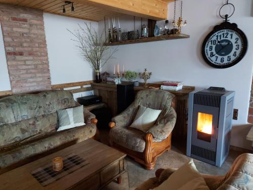 a living room with two chairs and a fireplace at Apartamenti Dundaga XXL in Dundaga