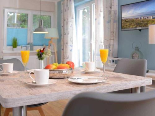 a dining room table with glasses of orange juice at Florida Haus am Strand in Boltenhagen