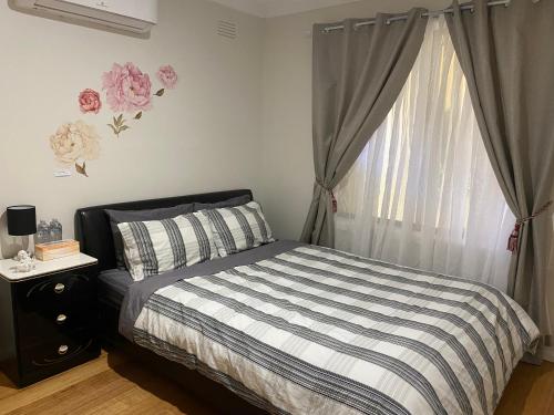 um quarto com uma cama e uma janela com rosas rosas em Rose House em Deer Park