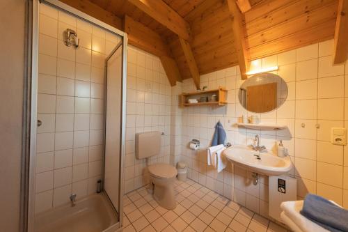 ein Bad mit einer Dusche, einem WC und einem Waschbecken in der Unterkunft VS 7 - Strandvogt Standard in Dorum Neufeld