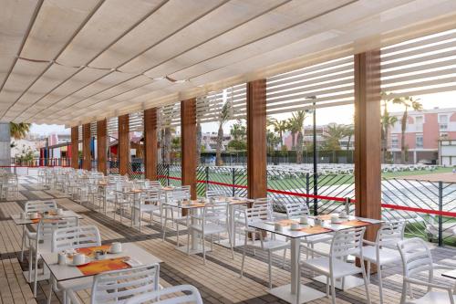 a restaurant with white tables and white chairs at Dos Playas - 30º hotels in Puerto de Mazarrón