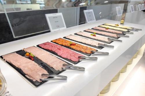 a buffet line with different types of meat and vegetables at Dos Playas - 30º hotels in Puerto de Mazarrón