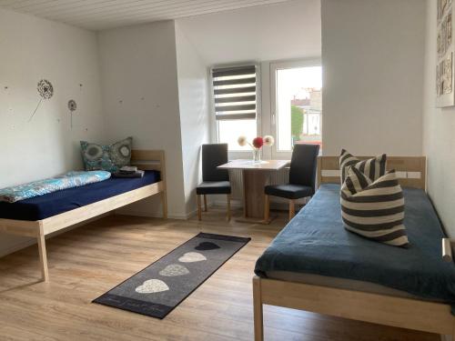 Zimmer mit 2 Betten und einem Tisch mit Stühlen in der Unterkunft Ferienwohnung Zeitz Appartment Zeitzer Dom in Zeitz