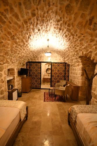um quarto com duas camas numa parede de pedra em Hanedan Konağı Butik Otel Deluxe Double Room With Turkish Bath By Bero em Mardin