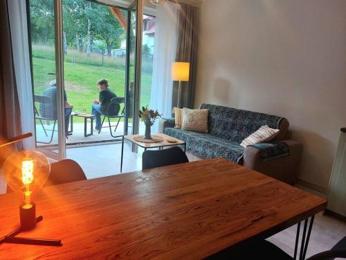 - un salon avec une table en bois et un canapé dans l'établissement Sunny Mountain Lodge, à Szklarska Poręba