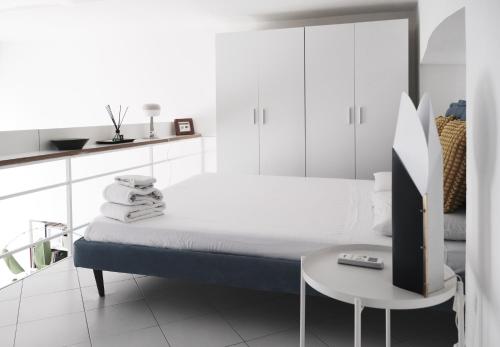 een witte slaapkamer met een bed en een tafel bij ComeCasa Grazioso Loft in Crocetta in Milaan