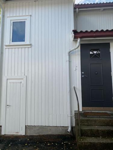 - un bâtiment blanc avec une porte noire et une fenêtre dans l'établissement Mycondo no - Snorres gt 4b apt 1 - Gratis parkering, à Tønsberg