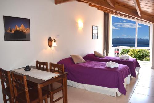 une chambre avec deux lits et une table et une fenêtre dans l'établissement Studio Bariloche, à San Carlos de Bariloche