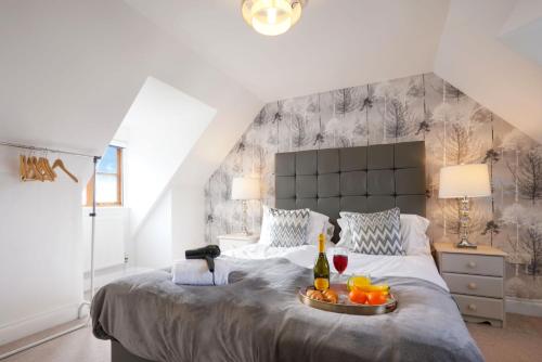a bedroom with a large bed with a tray of fruit on it at Loughton House - Central Location - Free Parking, Private Garden, Super-Fast Wifi and Smart TVs by Yoko Property in Milton Keynes